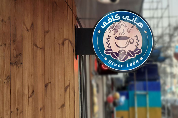 تابلوی چرخان نصب شده بر روی سردر ورودی کافه.